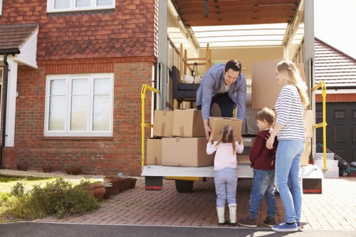 Removalists handling furniture near a Brompton townhouse and driveway access